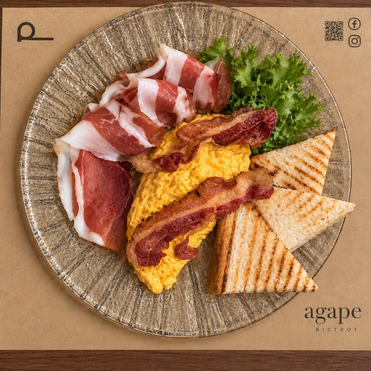 Colazione salata di Agapé Bistrot con uova strapazzate, salumi, bacon, insalata e toast